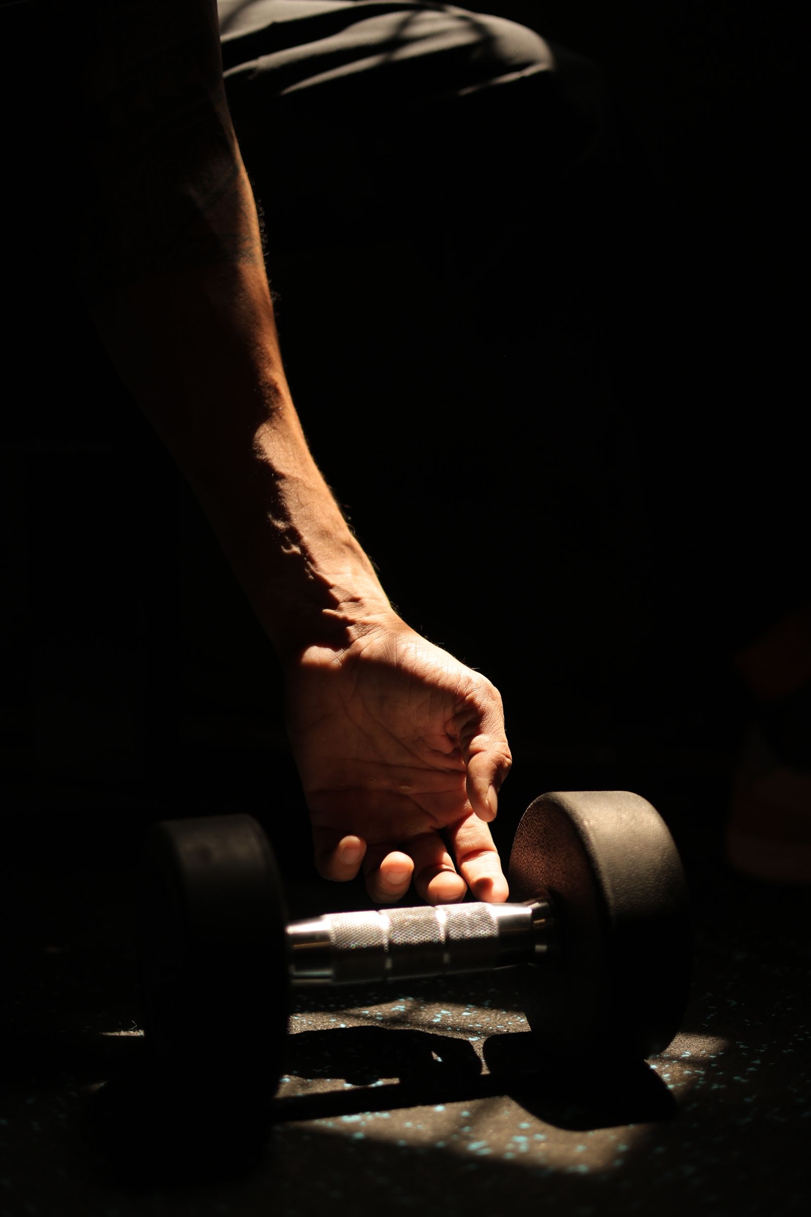 Member gripping a dumbbell at IronPulse